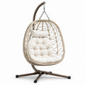 Sedia sospesa in rattan con struttura in metallo e cuscino color crema